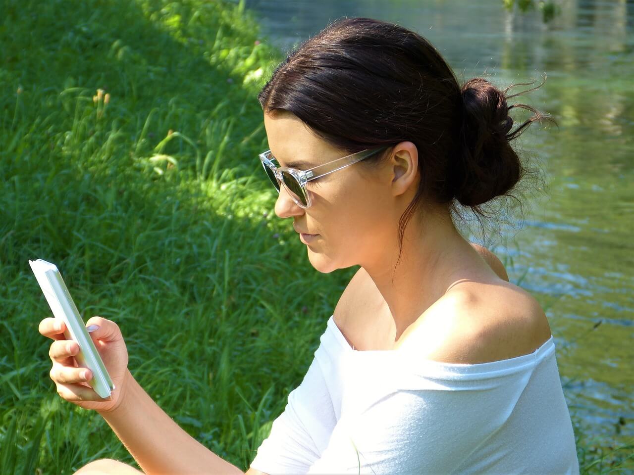 Mulher consulta seu telefone celular.